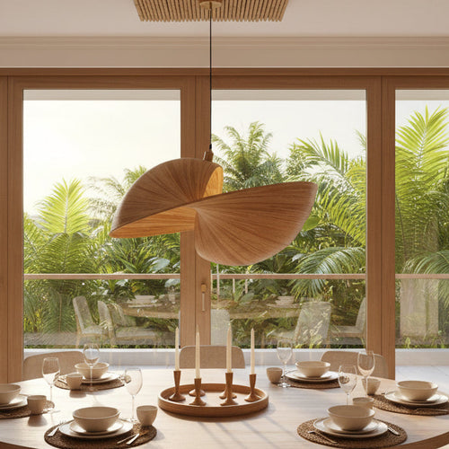 A modern dining room with a round wooden table set with white dishes, surrounded by beige chairs. A large, sculptural wooden pendant light hangs over the table.
