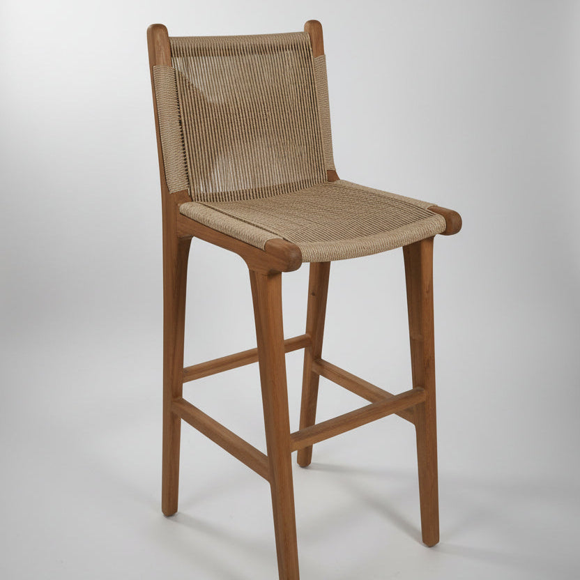 Wooden bar stool with woven backrest in a casual setting