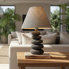 Table lamp with stone base and gray shade on a wooden surface