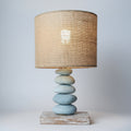 Table lamp with a woven shade on a wooden cabinet against a light gray wall
