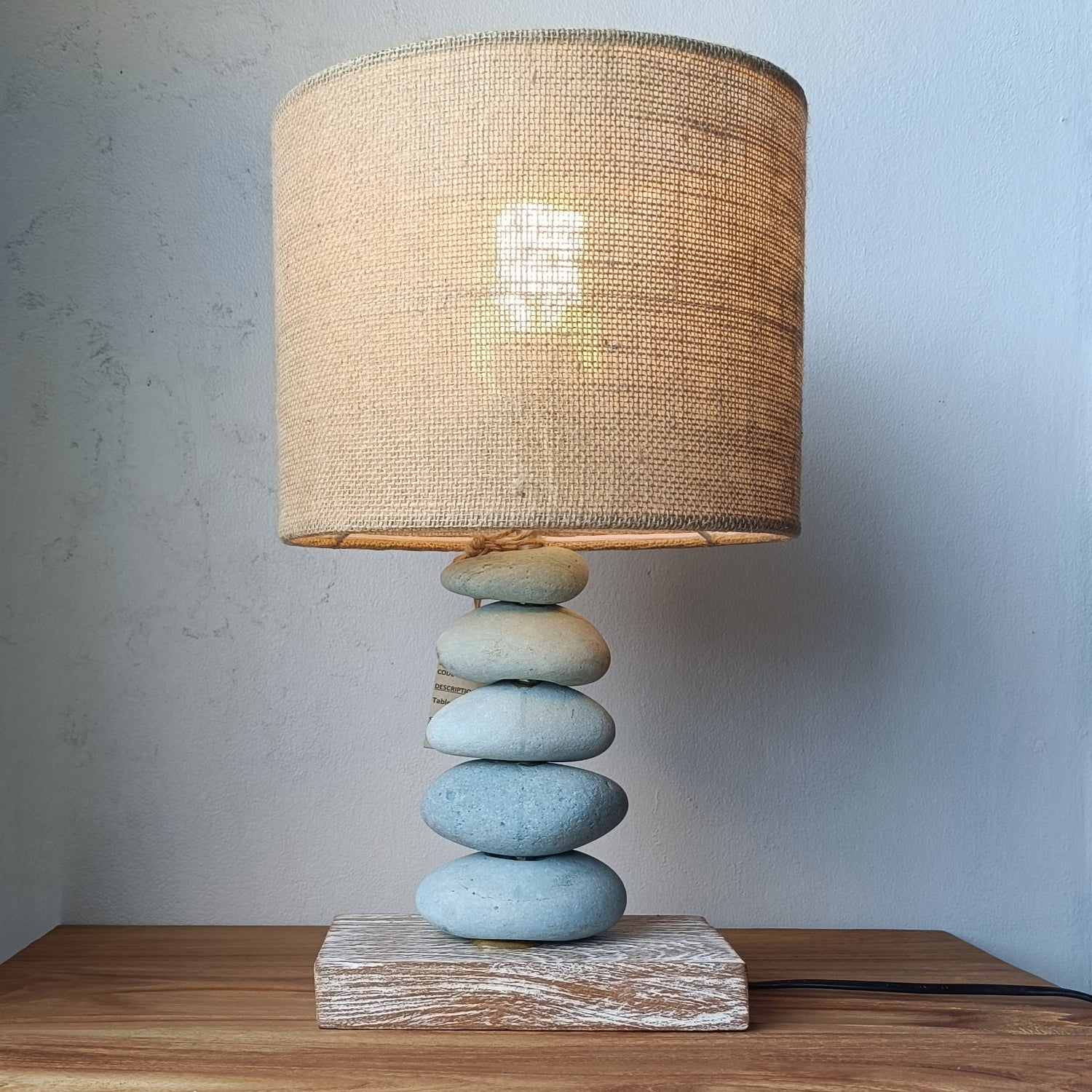 Table lamp with a woven shade on a wooden cabinet against a light gray wall