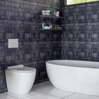 Modern bathroom with dark tiled walls, white toilet, and freestanding bathtub.