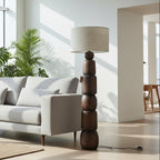Modern living room with a gray sofa, wooden lamp, and large windows.