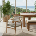 Dining area with wooden furniture and a view of the ocean and palm trees.