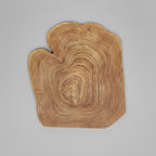 A large rustic wooden serving board with an organic, tree-cross-shaped silhouette and prominent concentric wood grain patterns, shown on a neutral gray background.