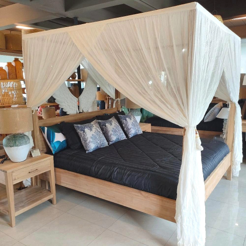 Wooden canopy bed with black mattress and decorative pillows in a room setting.