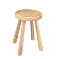 A simple wooden stool made of recycled teak wood, with a flat round seat and three sturdy legs.