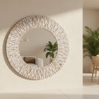 Round decorative mirror frame 
in whitewashed wood on a wall.