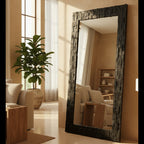 Large decorative mirror with a textured frame in a living room setting.