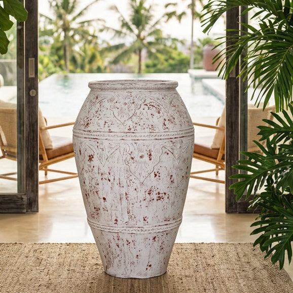 A large distressed white ceramic planter pot with red speckled detailing and embossed floral patterns.
