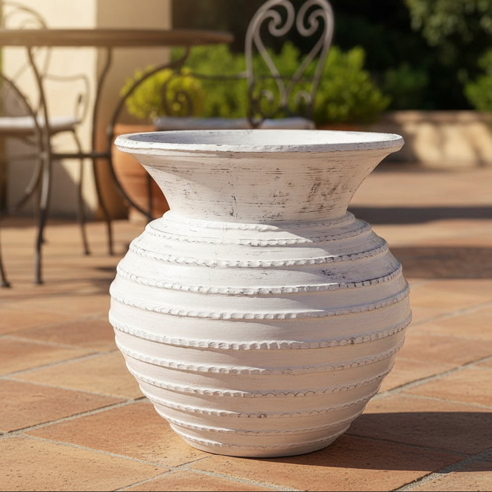 White textured vase on a patio with outdoor furniture in the background