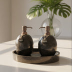 Two black marble soap dispensers labeled 'Shampoo' and 'Conditioner' on a matching tray.