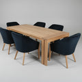 Wooden dining table with six black chairs on a gray background