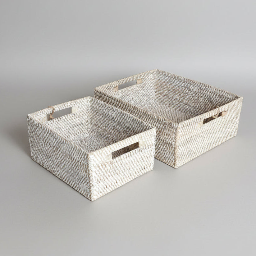 Two woven rectangular towel storage baskets with cutout handles