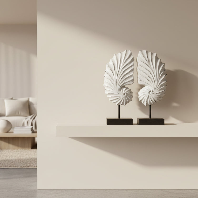 Two decorative shell sculptures on stands against a white background