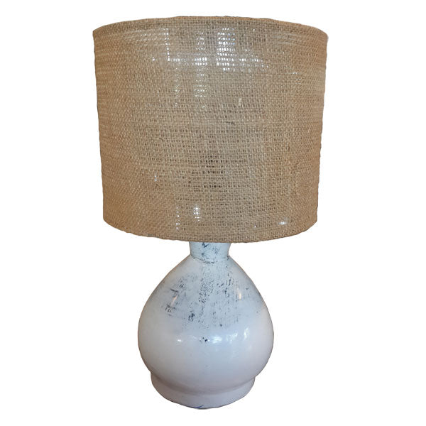A bedside lamp with a hand-painted terracotta base in white color and a shade made of hemp, with a natural beige tone.