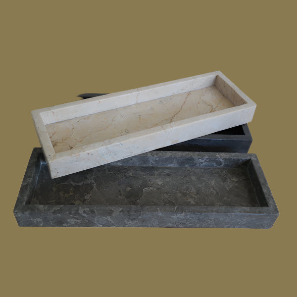 Two rectangular marble bathroom countertop amenities trays, one stacked on top of the other. The top tray is beige marble, and the bottom one is black marble.