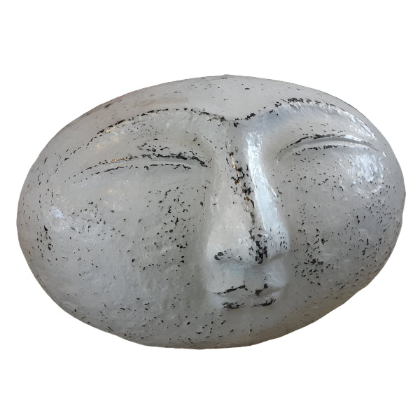 A sculpture of a smiling face with closed eyes, finished in black paint.