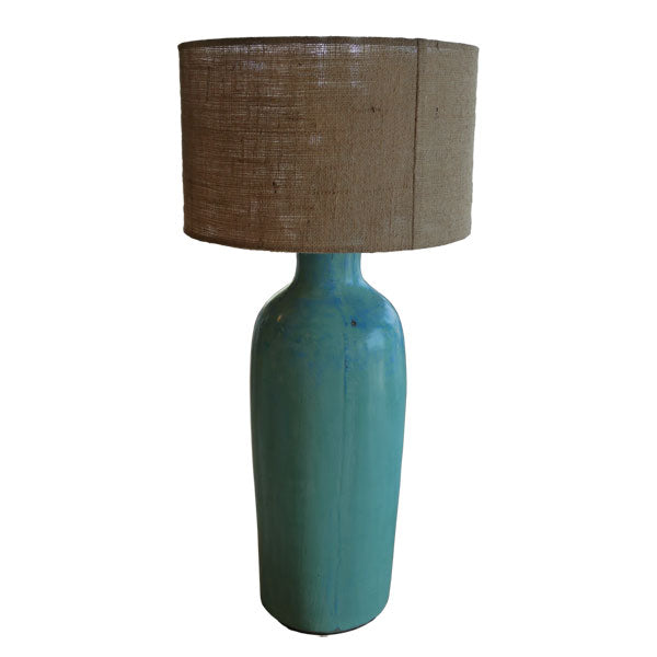 A modern table light with a beige lampshade and a white base with grey speckles.