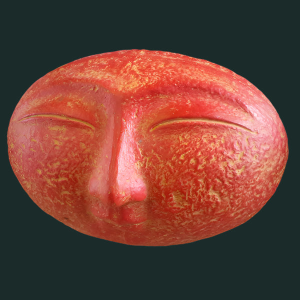 A sculpture of a smiling face with closed eyes, finished in black paint.